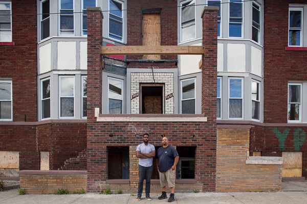 David Alade, left, and Steven Harris, right, on the steps of a building newly purchased by Harris