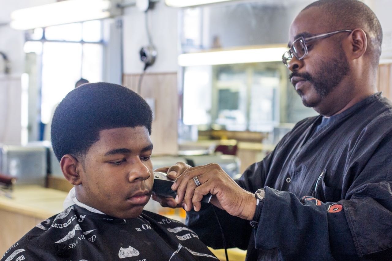 ?Lucas, 13, getting his hair cut by Metro Detroit Barber College owner Raymond Ware