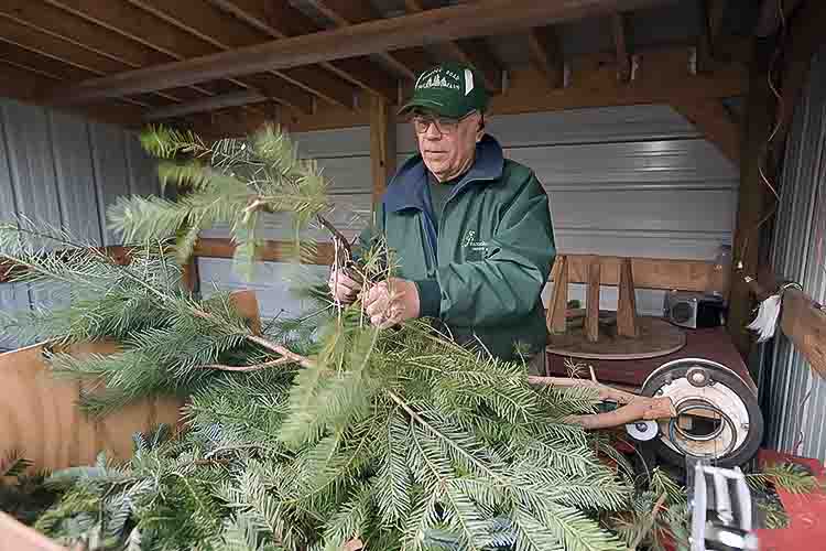 Ed Carpenter makes wreaths from excess boughs in their wreath making shop. Photo by David Trumpie 